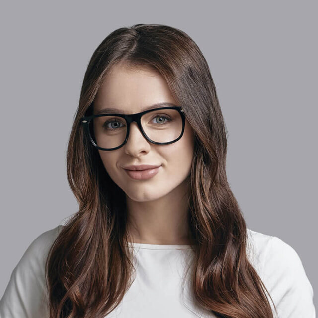 A woman with glasses is posing for the camera.