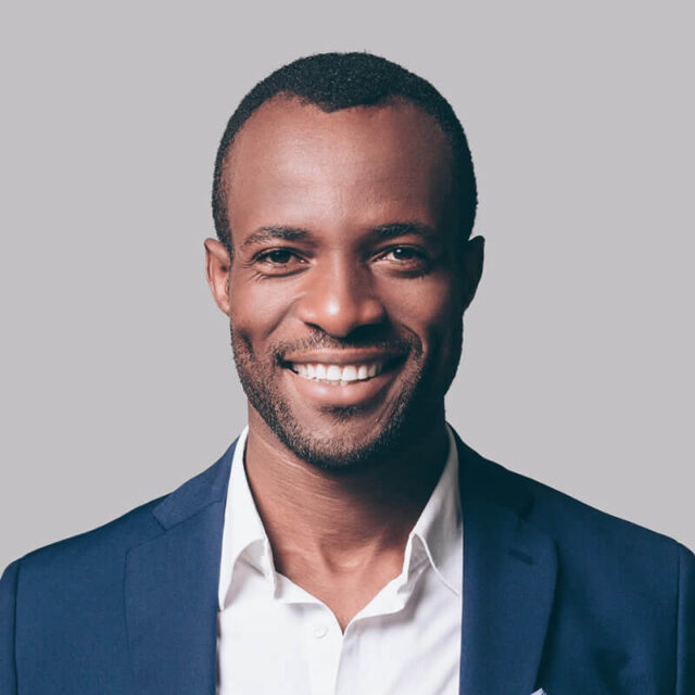 A man in a suit and tie smiling for the camera.